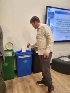 Man putting can into recycle bin
